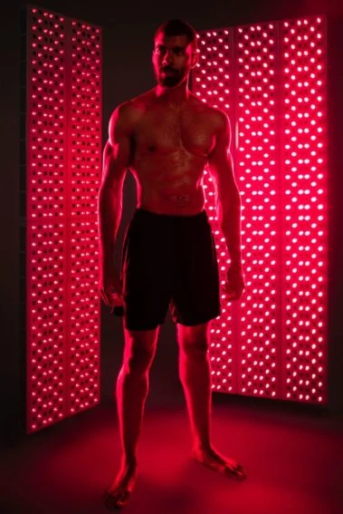 Man standing receiving Joovv Red Light Therapy treatment.