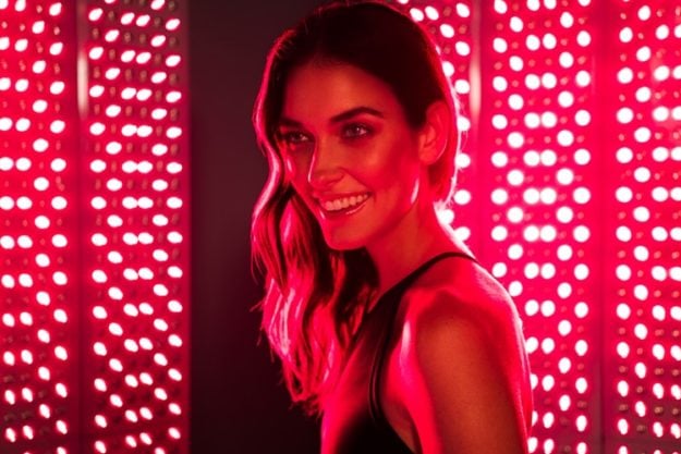 Smiling woman receiving Joovv Red Light Therapy.