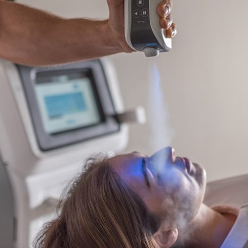 Man lying down receiving Cryotherapy Facial treatment.